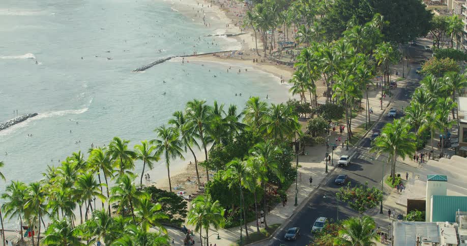 An aerial view of a beach with tourists beside the ocean