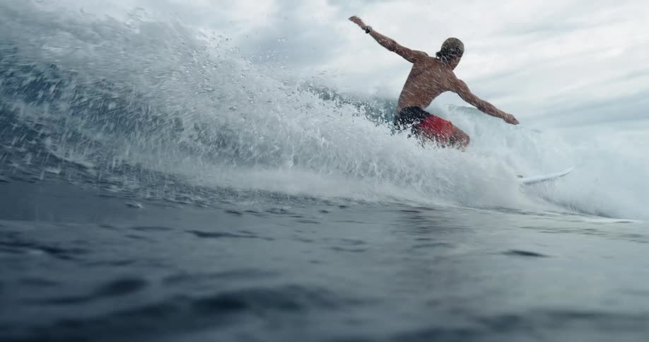 The man is riding a wave by the shore