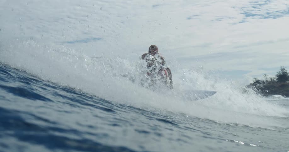 A surfer rides crashing waves in the open ocean