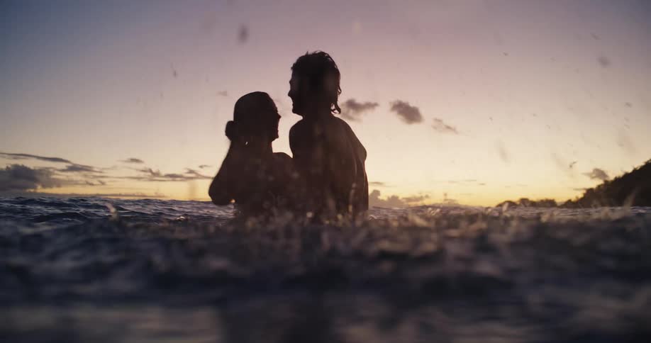 Silhouette of a couple in the sea at sunset