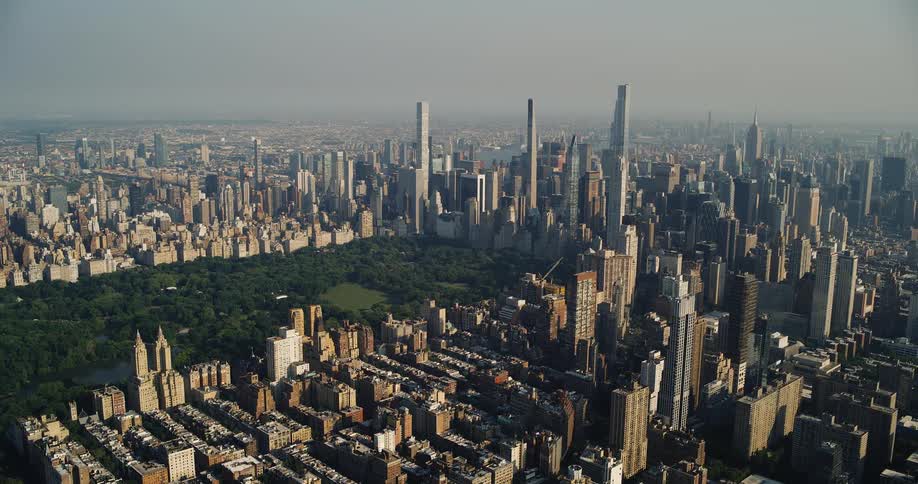 An aerial panorama reveals the vast expanse of new york city with central park as a vibrant green heart amidst the dense urban landscape