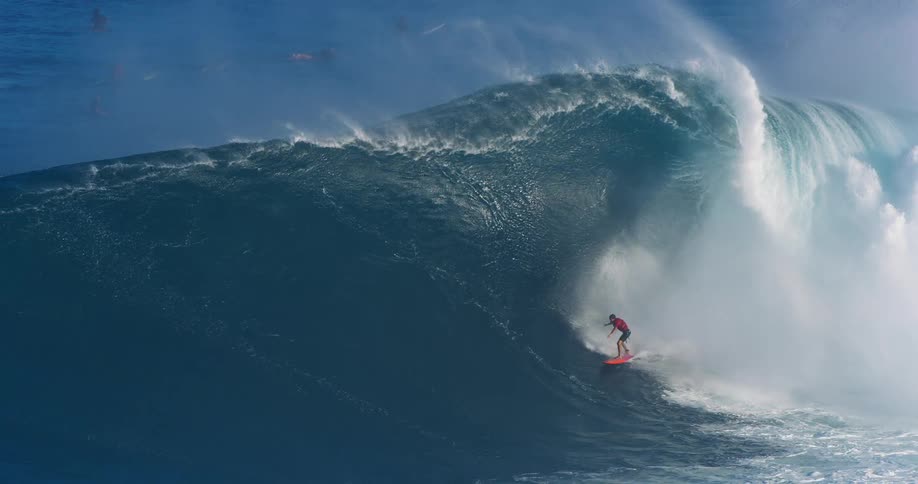 Surfer surfing down a large barrel wave then falling off as wave crashes