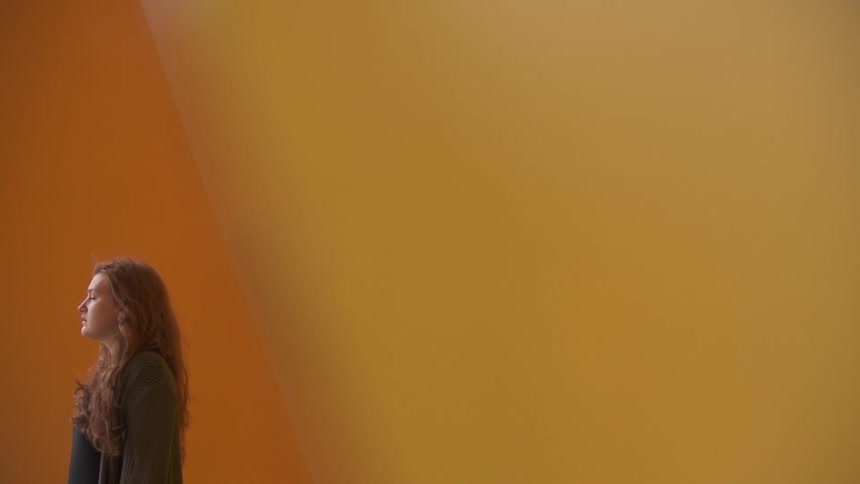 Woman in front of an orange wall