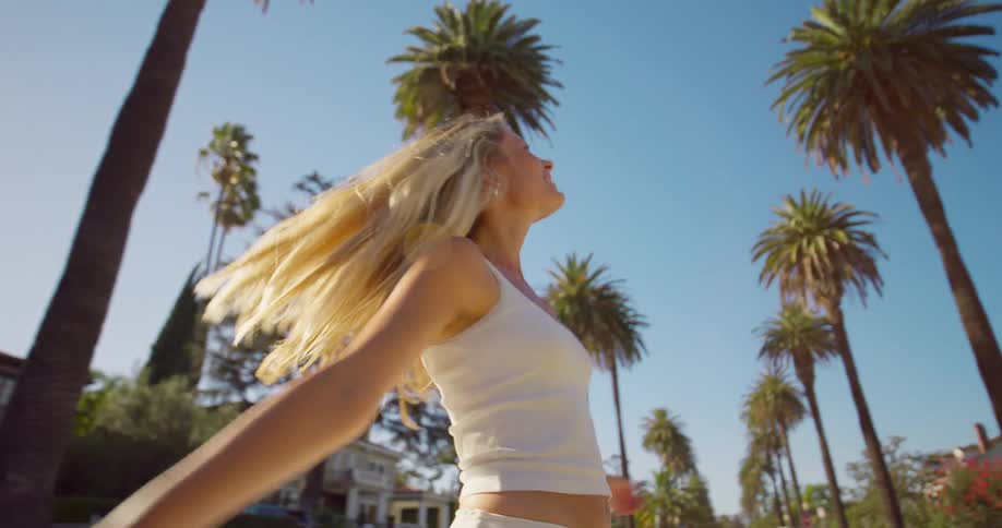 The woman walks on a sunny day spinning around as she moves