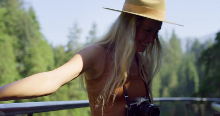 The woman smiles and turns on the perch above the forest