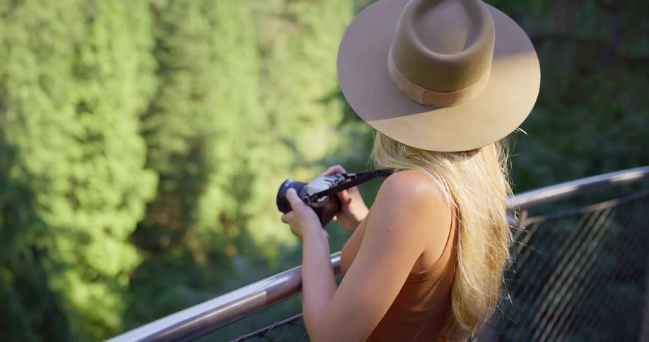 The woman is taking photos over the large forest
