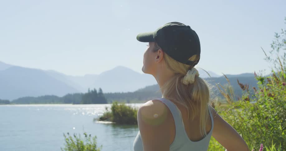 The woman smiles while looking over the lake