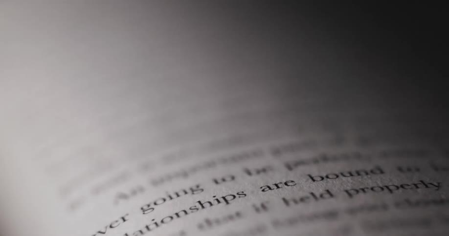 The text on a book page becomes blurry as the camera zooms in