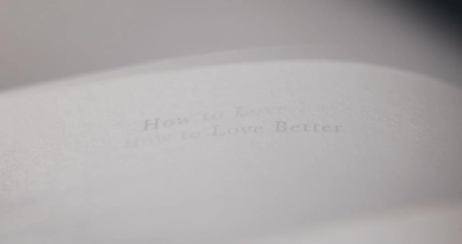 A video shows the pages of a book flipping followed by a closeup shot of a page with the title how to love better printed on it the camera then zooms out revealing the pages closing