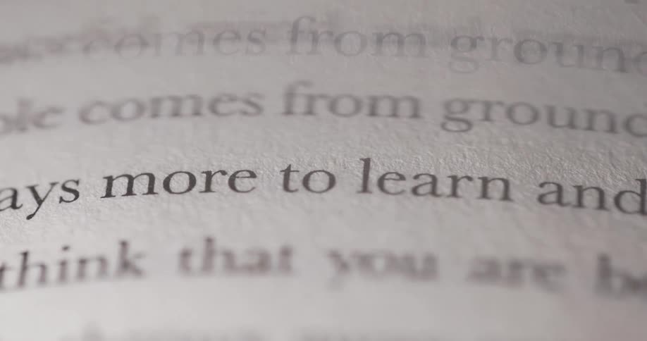 A blurry view of a printed page focuses a phrase in the center of the frame