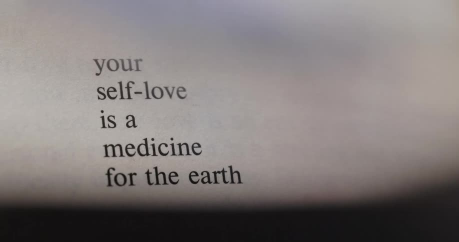 A page of a book is shown with the camera zooming in on a specific passage the text reads your selflove is a medicine for the earth