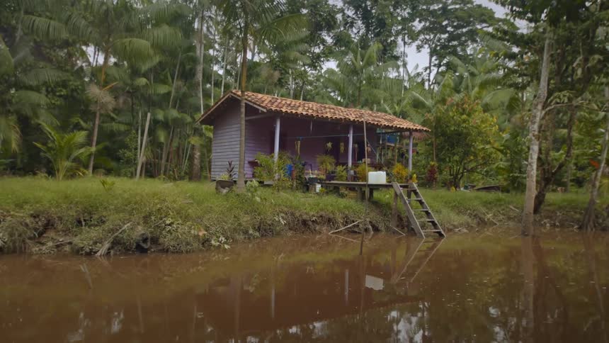 A small house is on the bank of a river