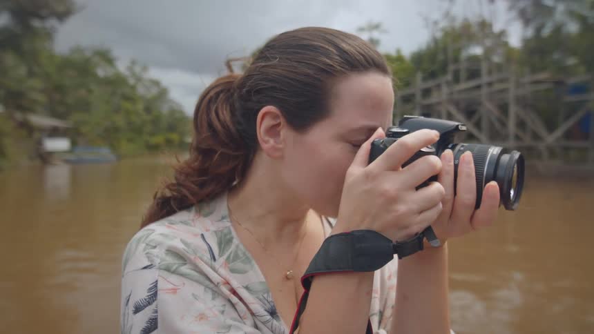 The woman takes photos while traveling in the water