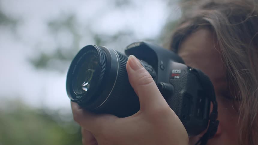 Woman frames a scene through her camera lens