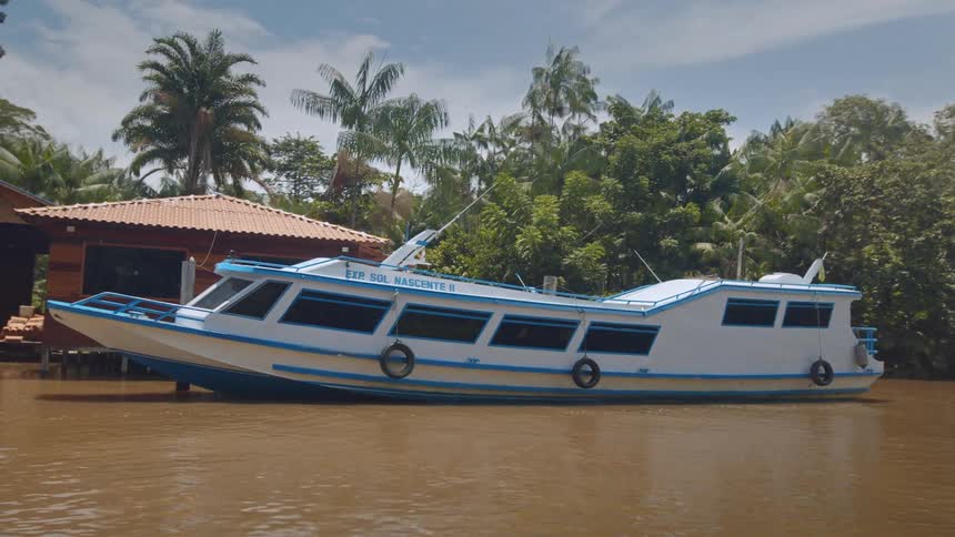 Large boats are docked at a house on stilts in the water