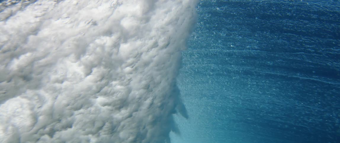 Underwater wave break shows intense mix of foam and blue water