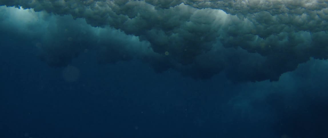 The large wave crashes sending waves underwater