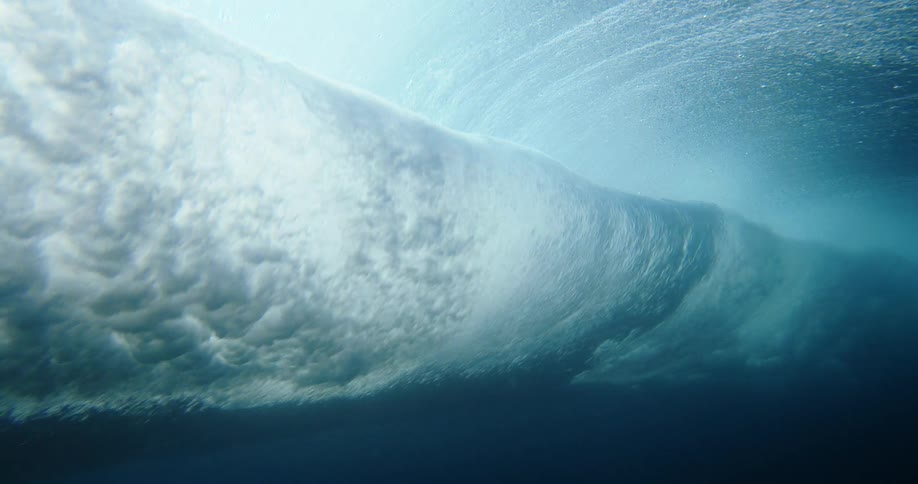 Wave seen from underwater forming a whirl of foam