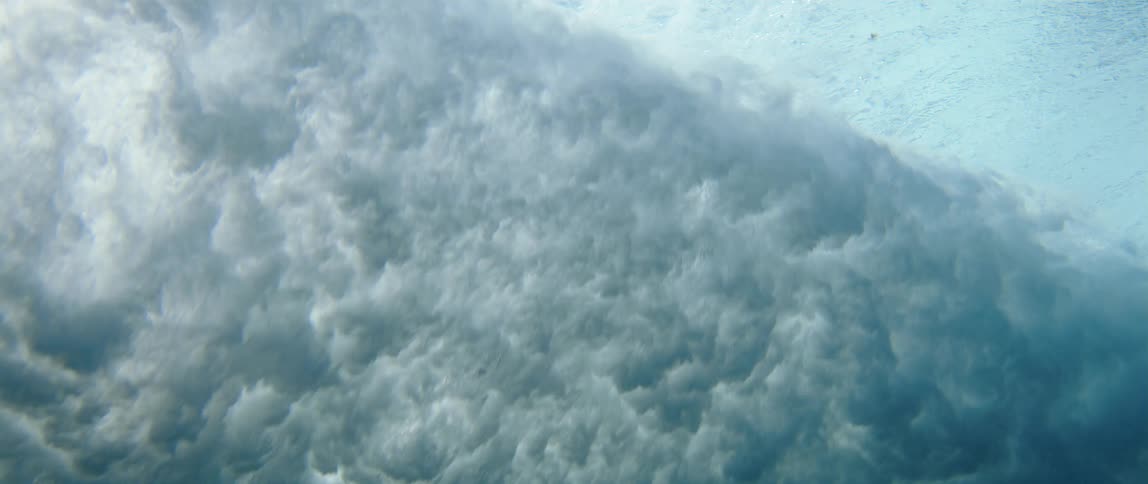 Ocean waves violently crashing against each other during high tide at midday
