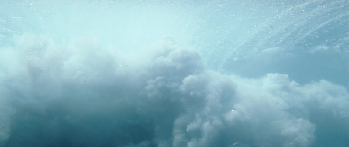 Mass of bubbles and foam forms underwater after a wave breaks