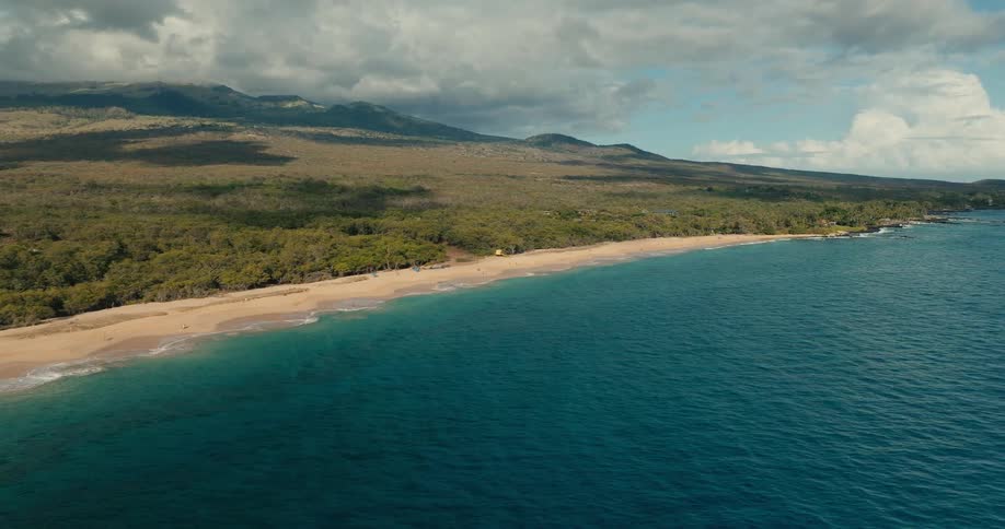 The blue water surrounds the beach