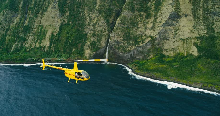 The helicopter flies past the coast
