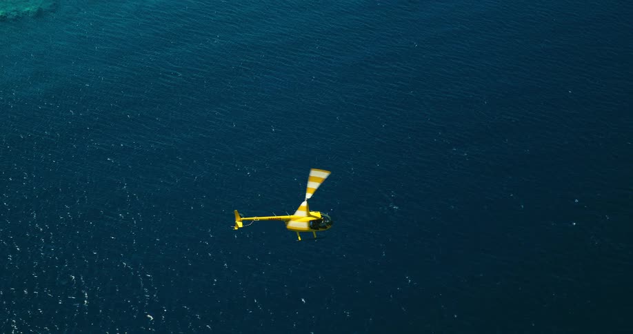 A helicopter is flying out over open water