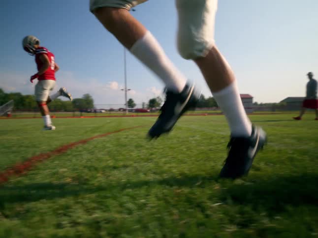 American football players on the field training in red and white uniforms