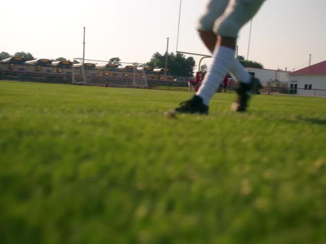 Close up of football players feet running through grass