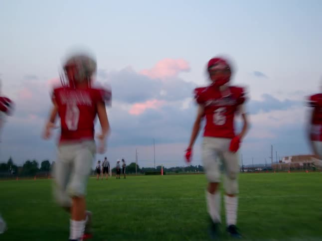 A football team does standing stretches on the field
