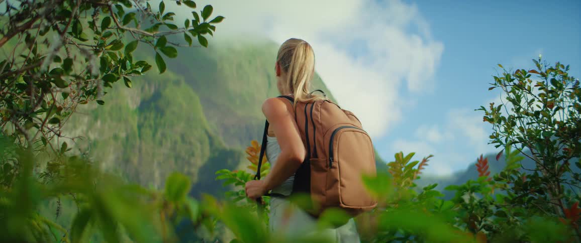 The woman smiles while hiking on the mountain