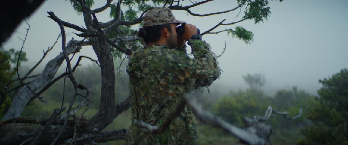 The hunter is looking out into the heavy fog