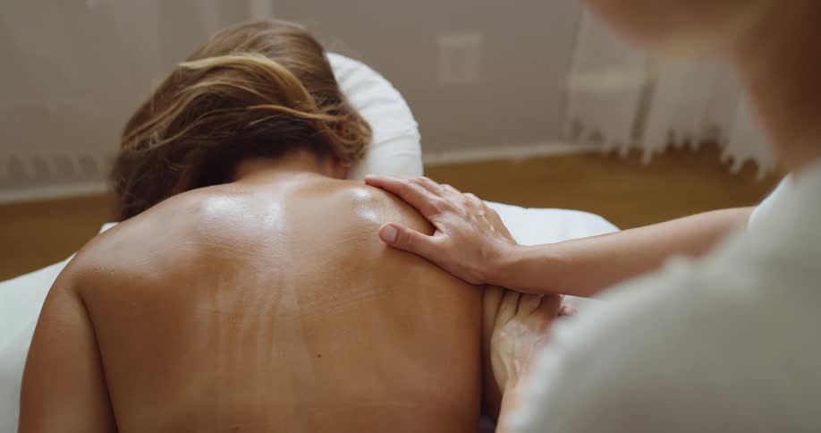 Therapist works the clients back for relief during a massage