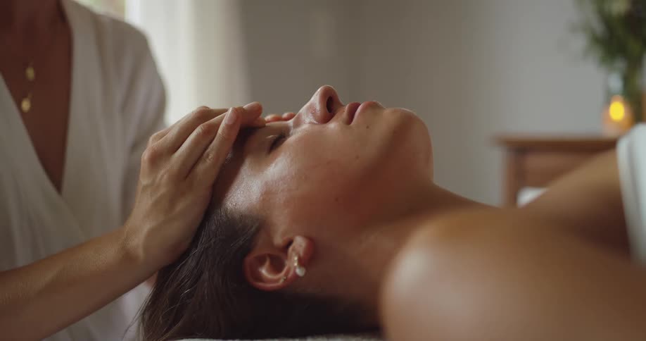 A woman giving a massage to another woman inside a spa at midday
