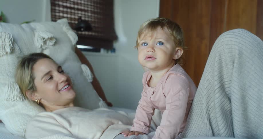 A mother and daughter lay in bed together