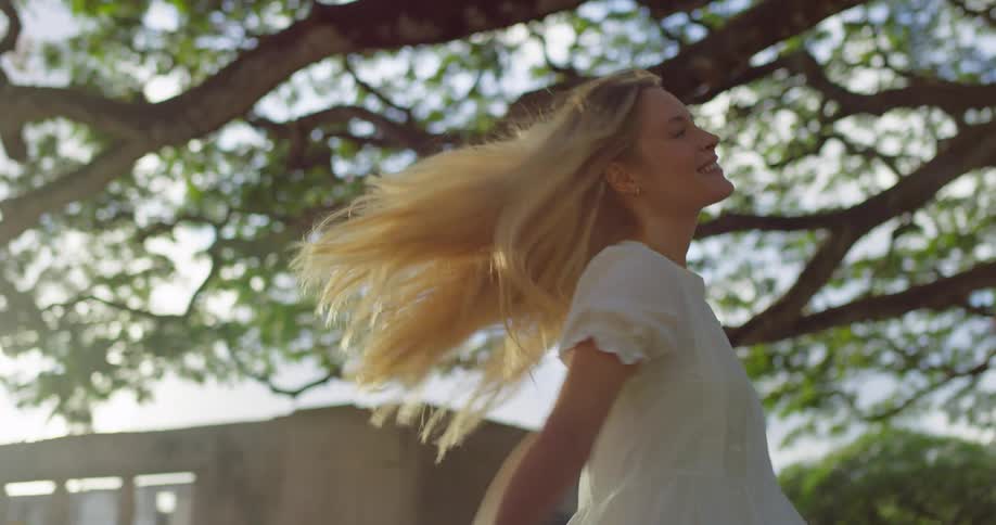 The woman spins under the large tree