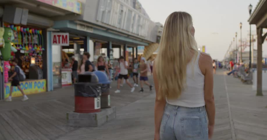 A woman walks through the crowds shopping on the boardwalk