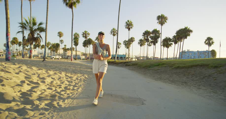 The woman smiles as she walks down the path