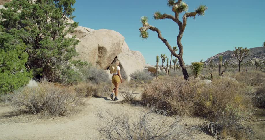 The woman his hiking towards the large rocks