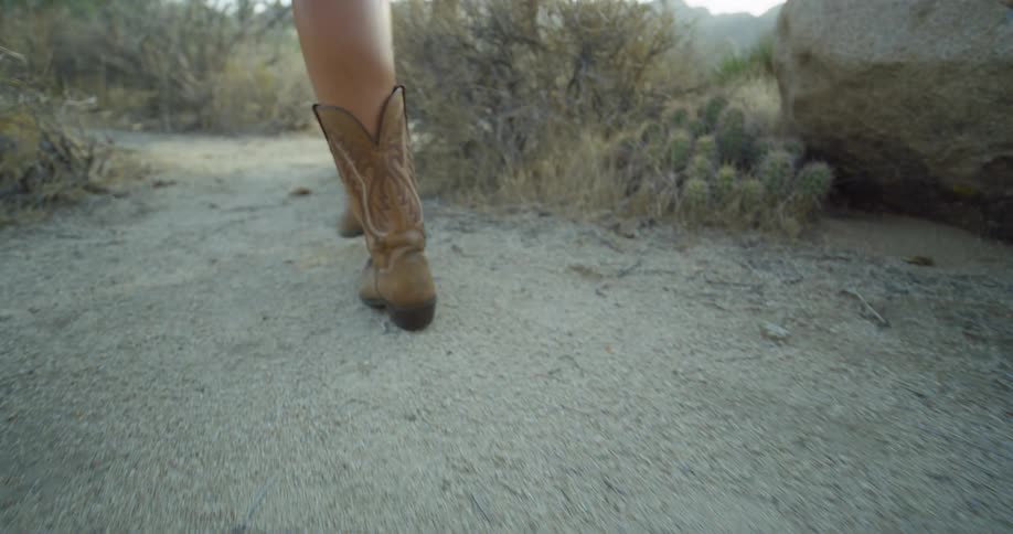 The woman is walking through the desert