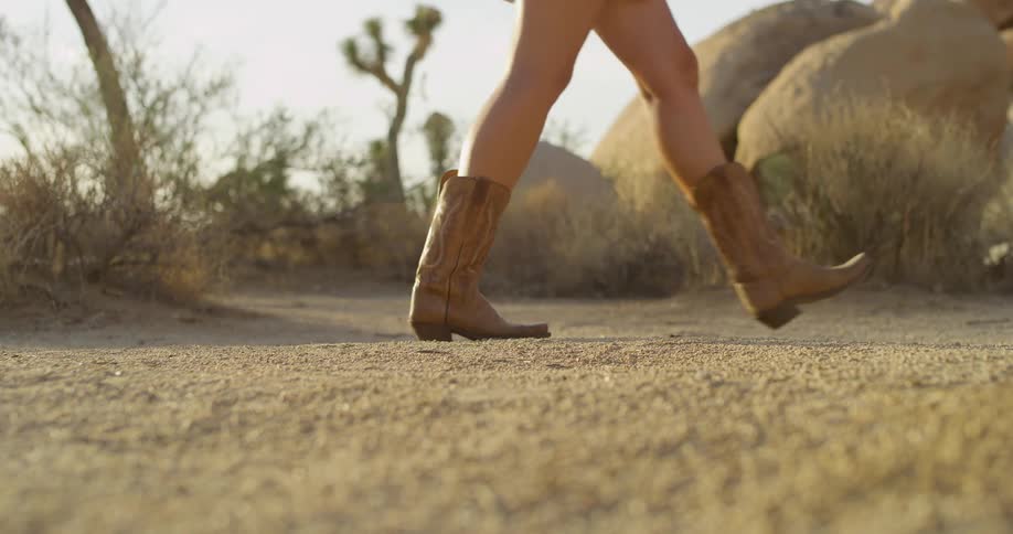 The woman walks past the boulders