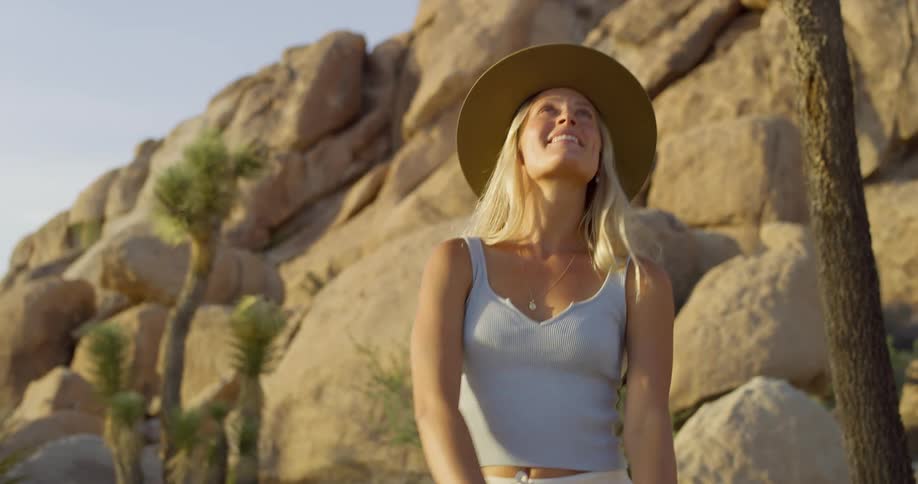 The woman smiles while hiking on a sunny day
