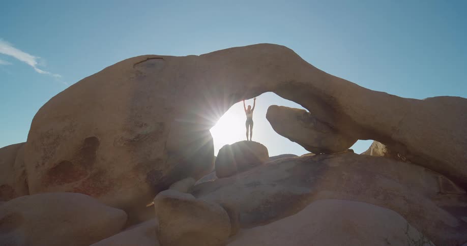 The woman is stretching on top of the canyon