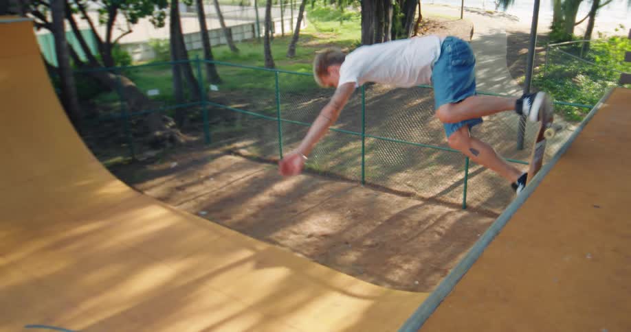 Youth skateboards on an u shaped skateboard structure at a park near the water on a summer day