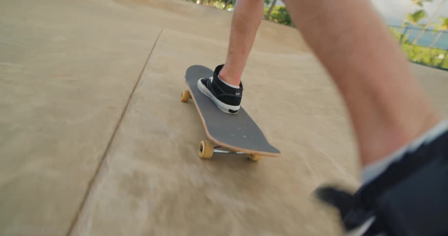 The video shows a lowangle shot of a male skateboarder at a skatepark he performs a grind on a concrete ledge and then a shoveit on the ramp rotating his board 180 degrees while keeping his feet on the ground