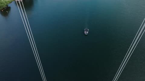 The boat is traveling towards the bridge