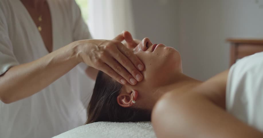Therapist performs a calm facial massage on a woman