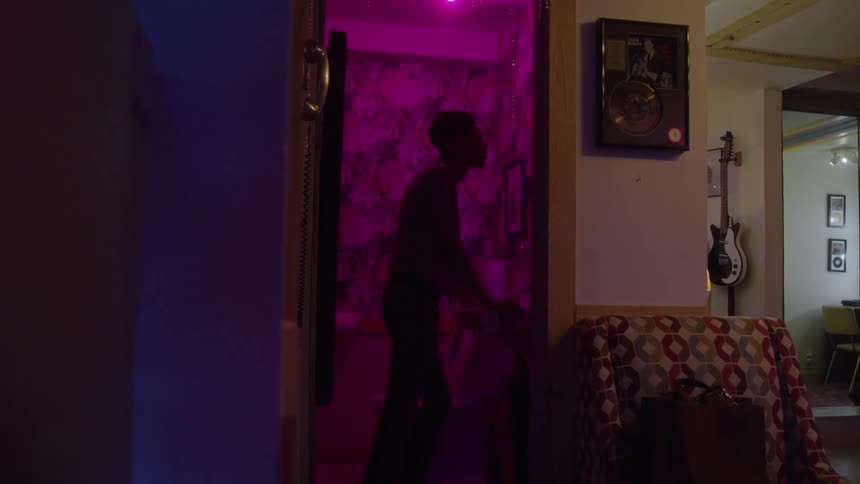 The man is standing in the dark bathroom