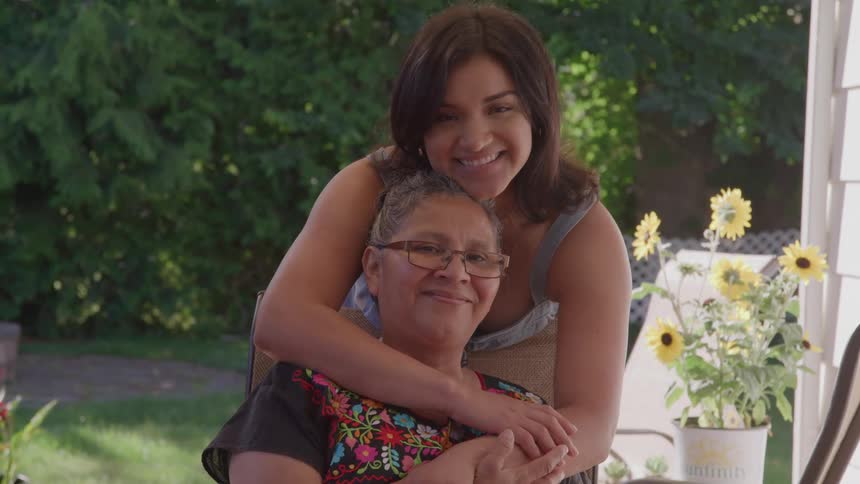 A granddaughter hugs her grandmother