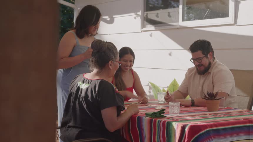Family sitting around a table enjoying time together outdoors